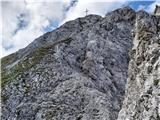 Lustige Bergler Steig in Innsbrucker Klettersteig - zavarovani poti nad Innsbruckom Nordkette: pogled proti križu na vrhu Kemacherja z izpostavljenega sestopa v škrbino, ki ji sledi vzdušno, ne pretirano težavno plezanje po kaminu proti vrhu
